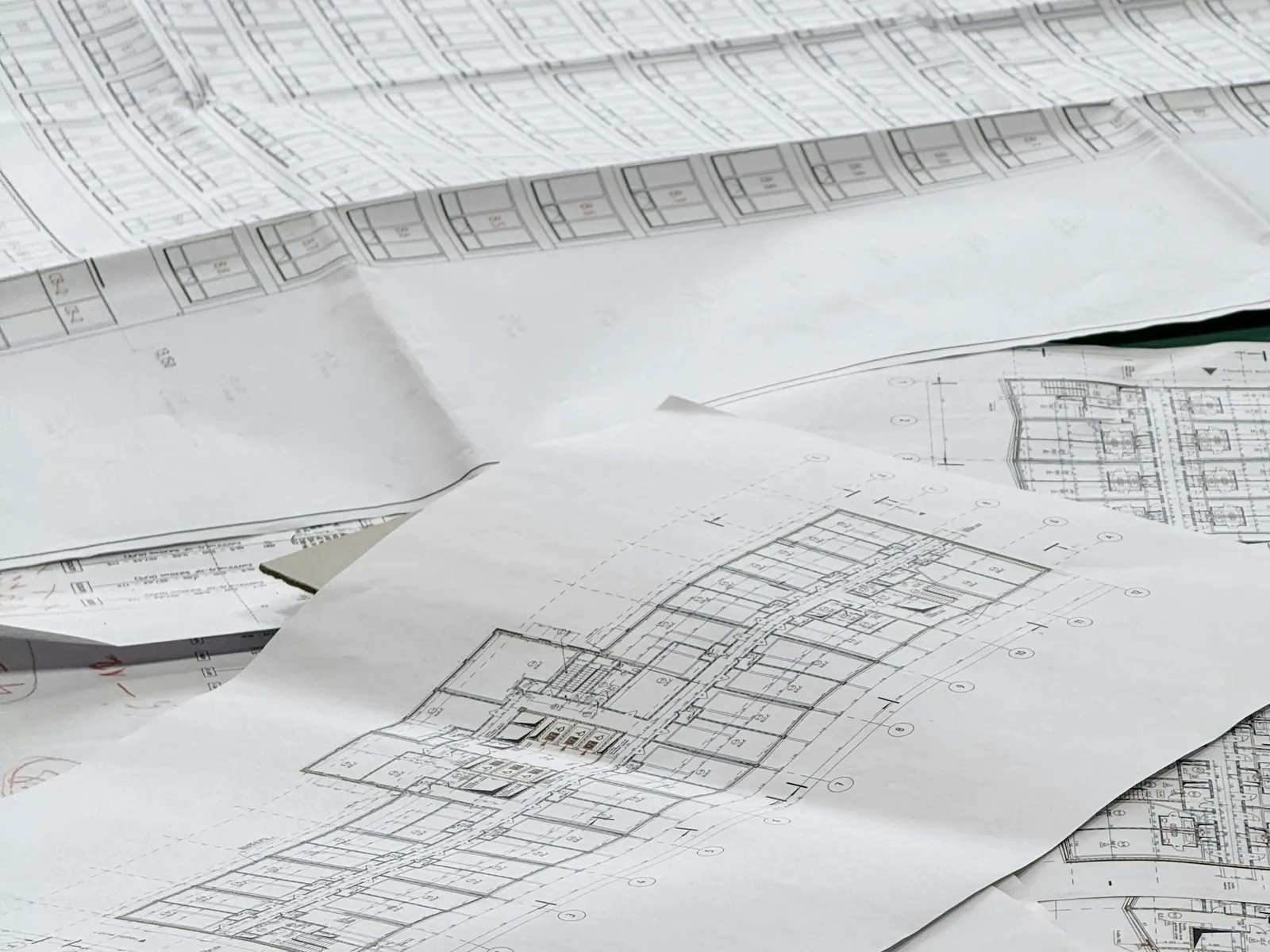 Printed architectural floor plans spread across a table